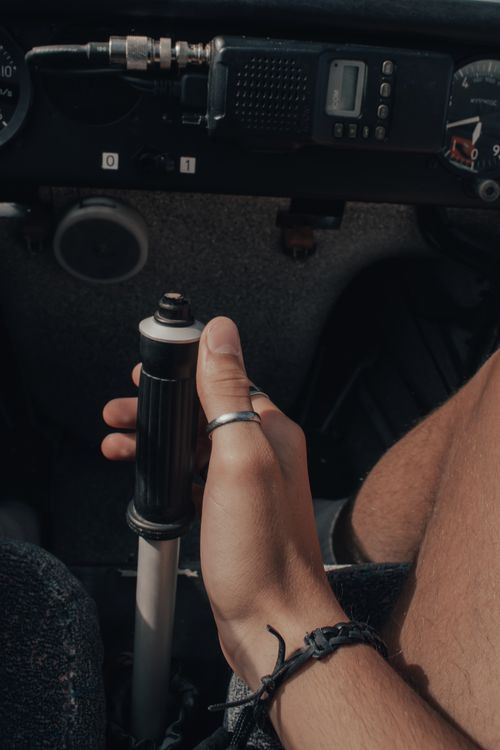 A hand gripping a manual gear stick inside a car