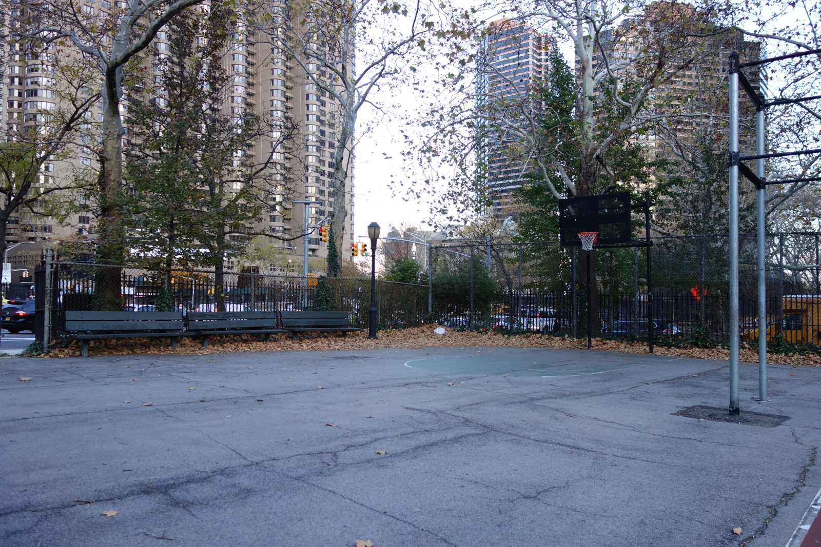 An outdoor basketball court in a city park