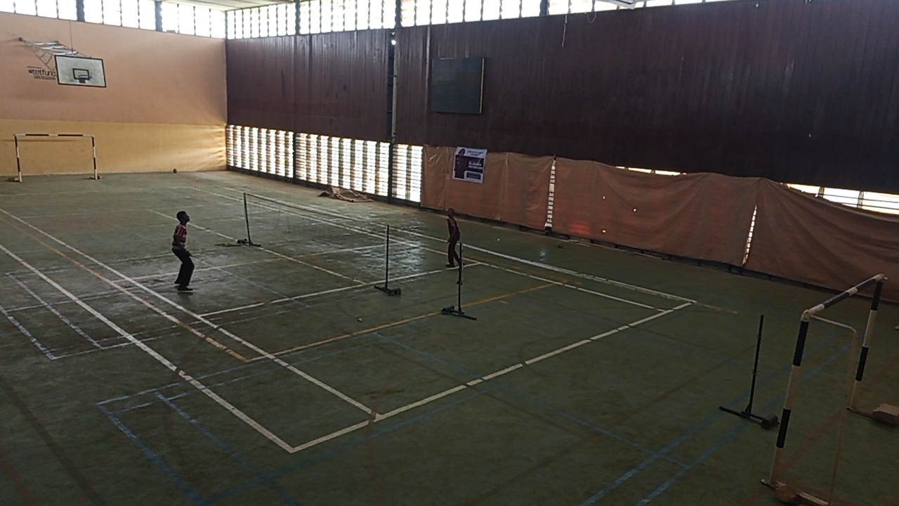 An indoor basketball hoop above court markings