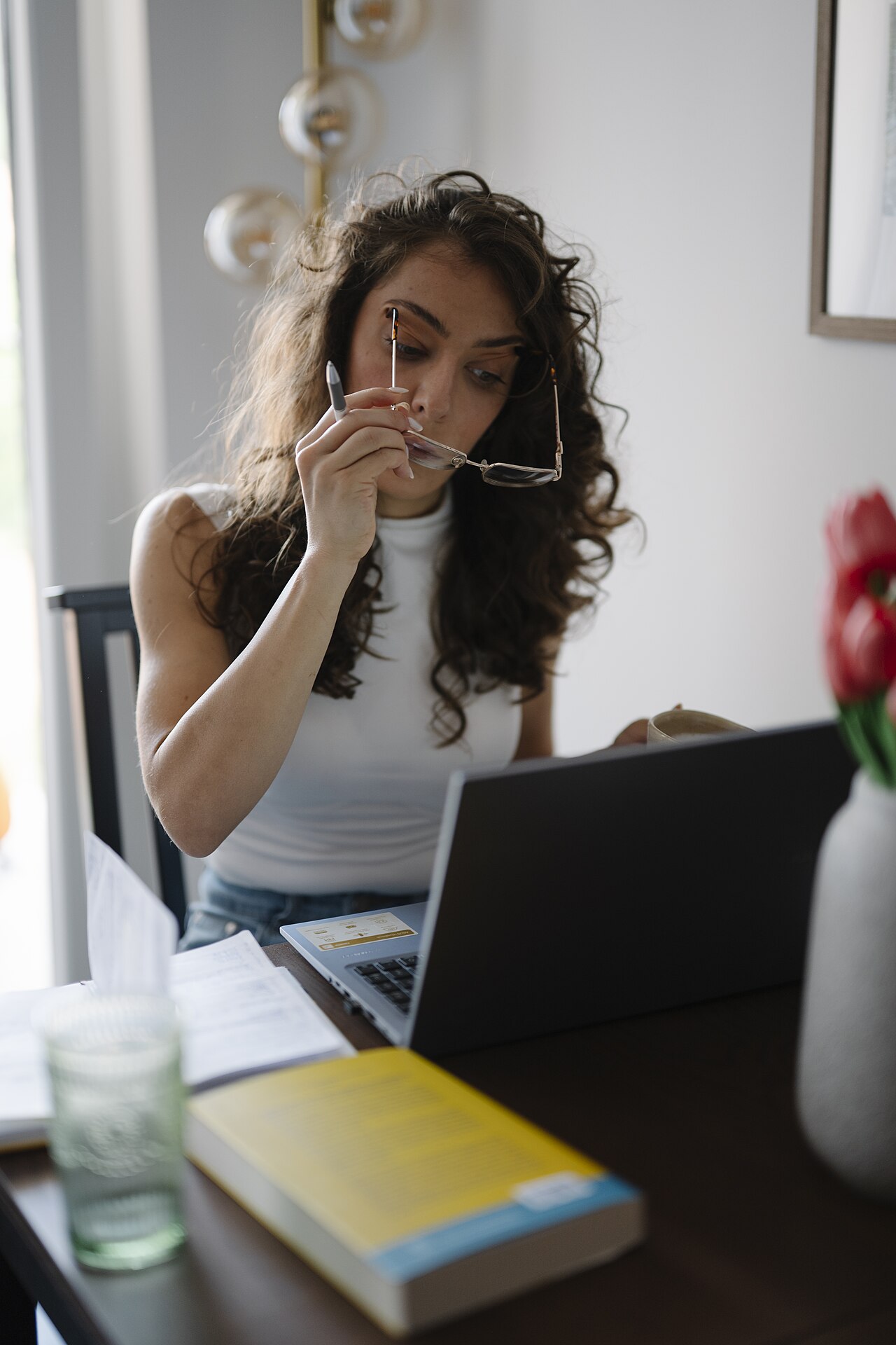 A woman working on a laptop at a table in a home office