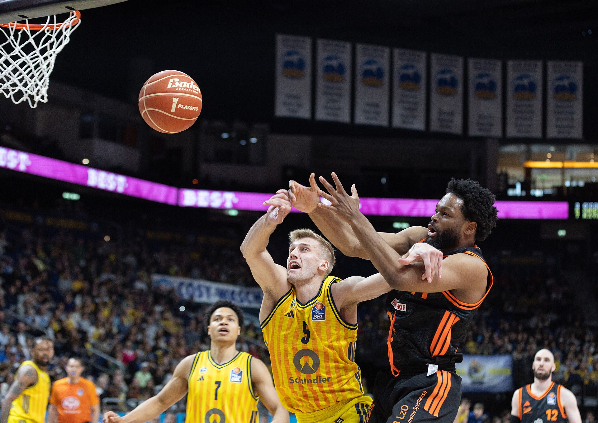Basketball players fight for the ball during a game