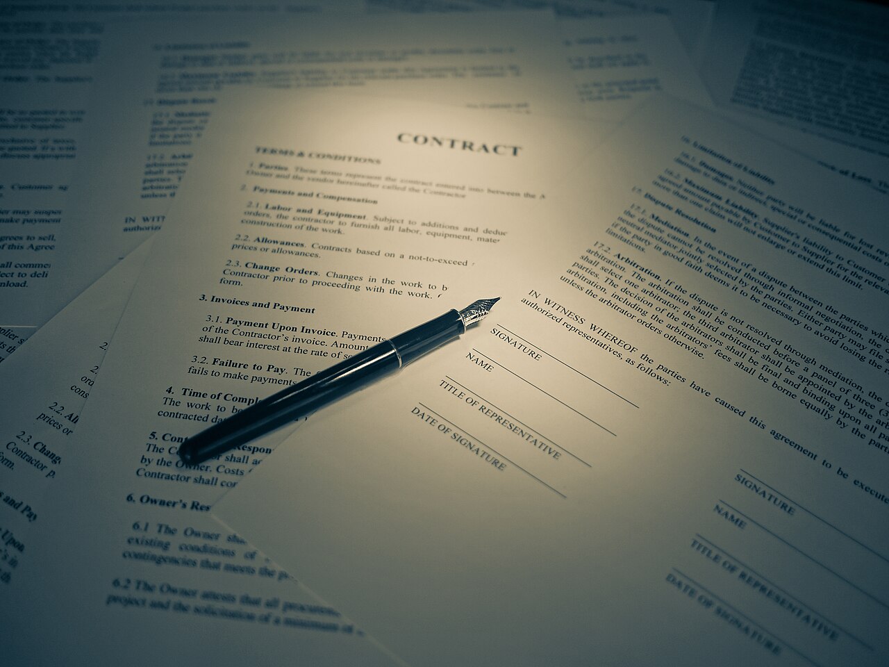 A contract with a signature block and a fountain pen