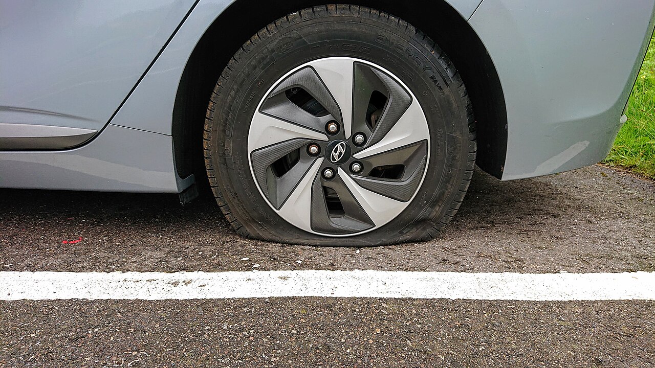 A damaged automobile tire that has lost its air