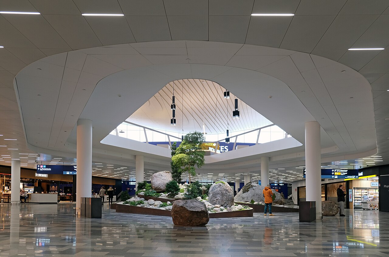 Travelers walking through a bright airport departure hall