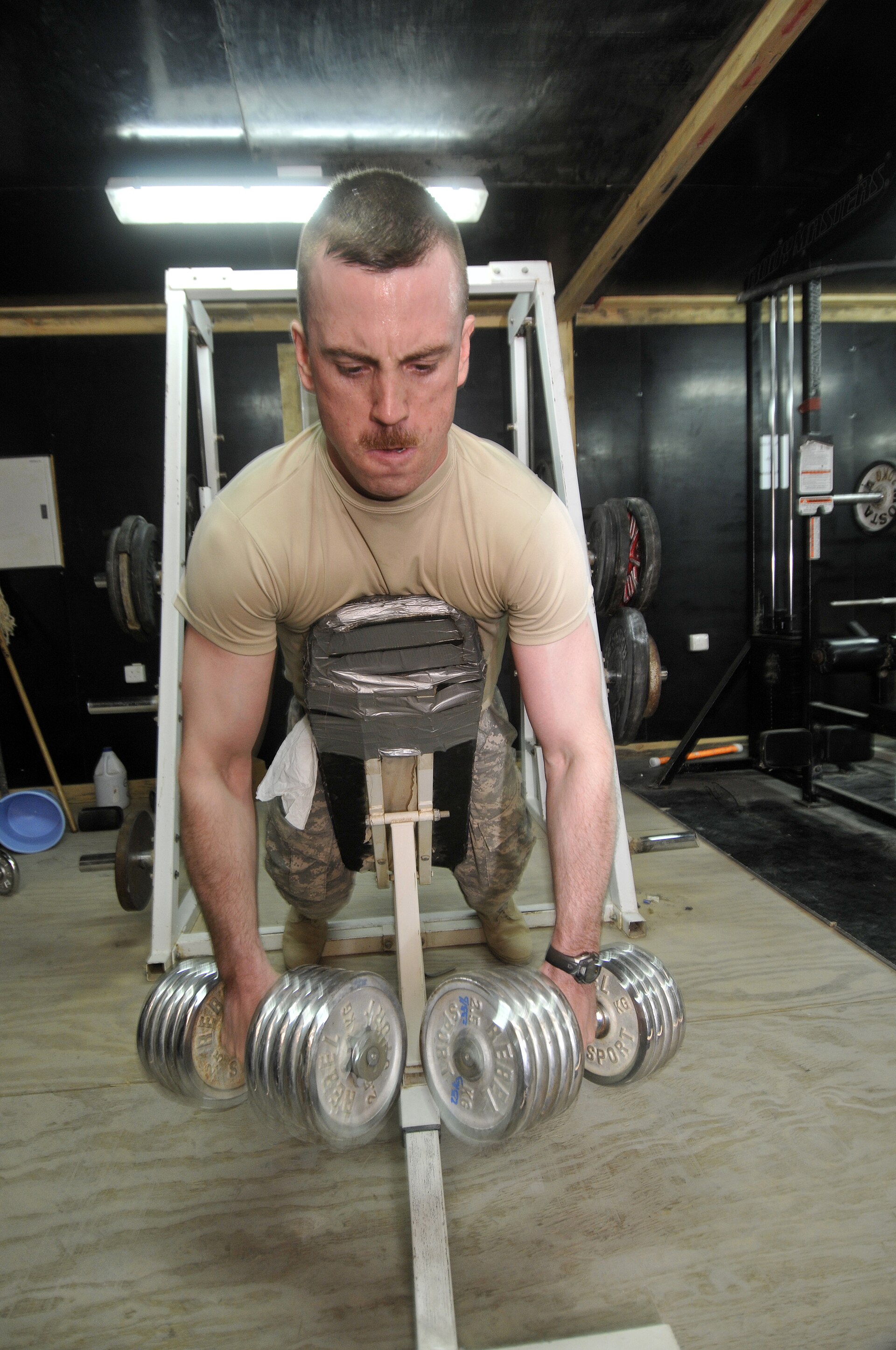A soldier lifting a barbell during weight training