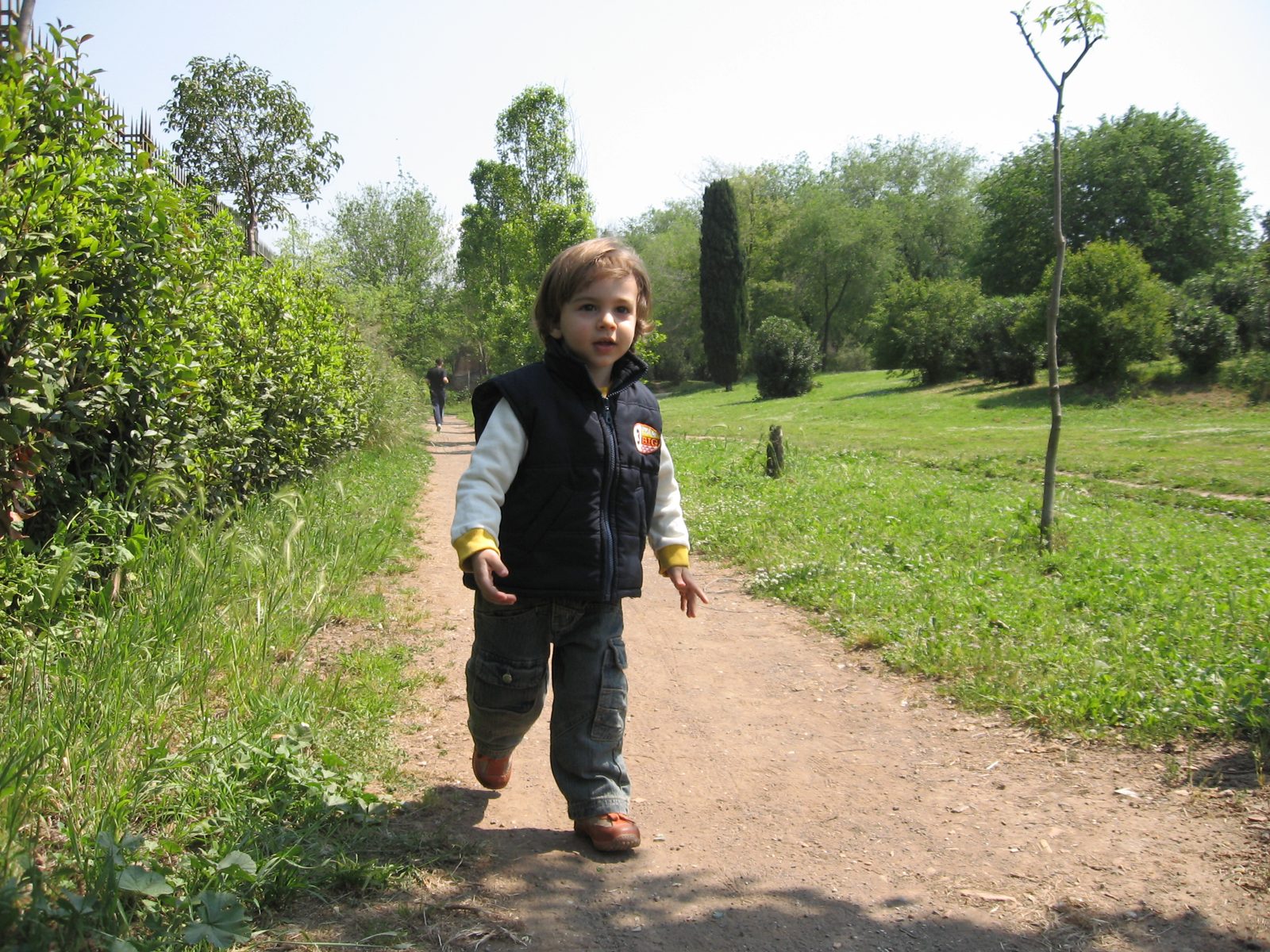 A young child running across an open grassy area