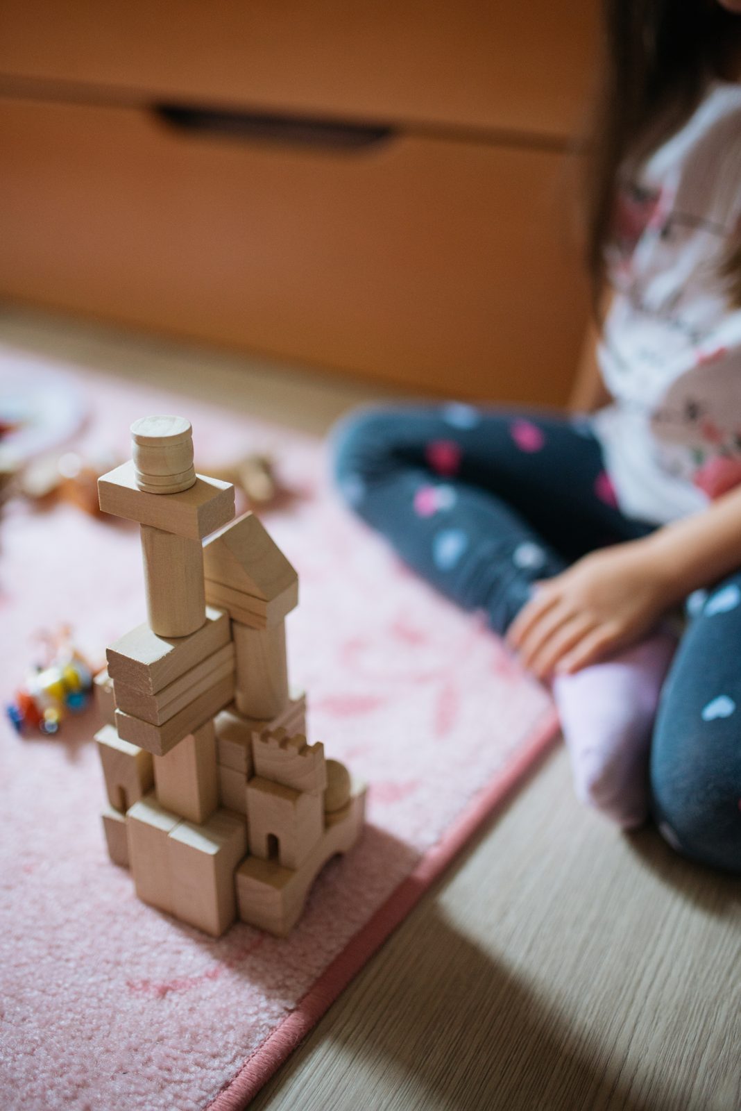 A child playing with wooden building blocks