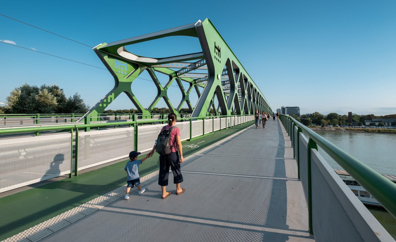 A mother and toddler crossing a bridge together