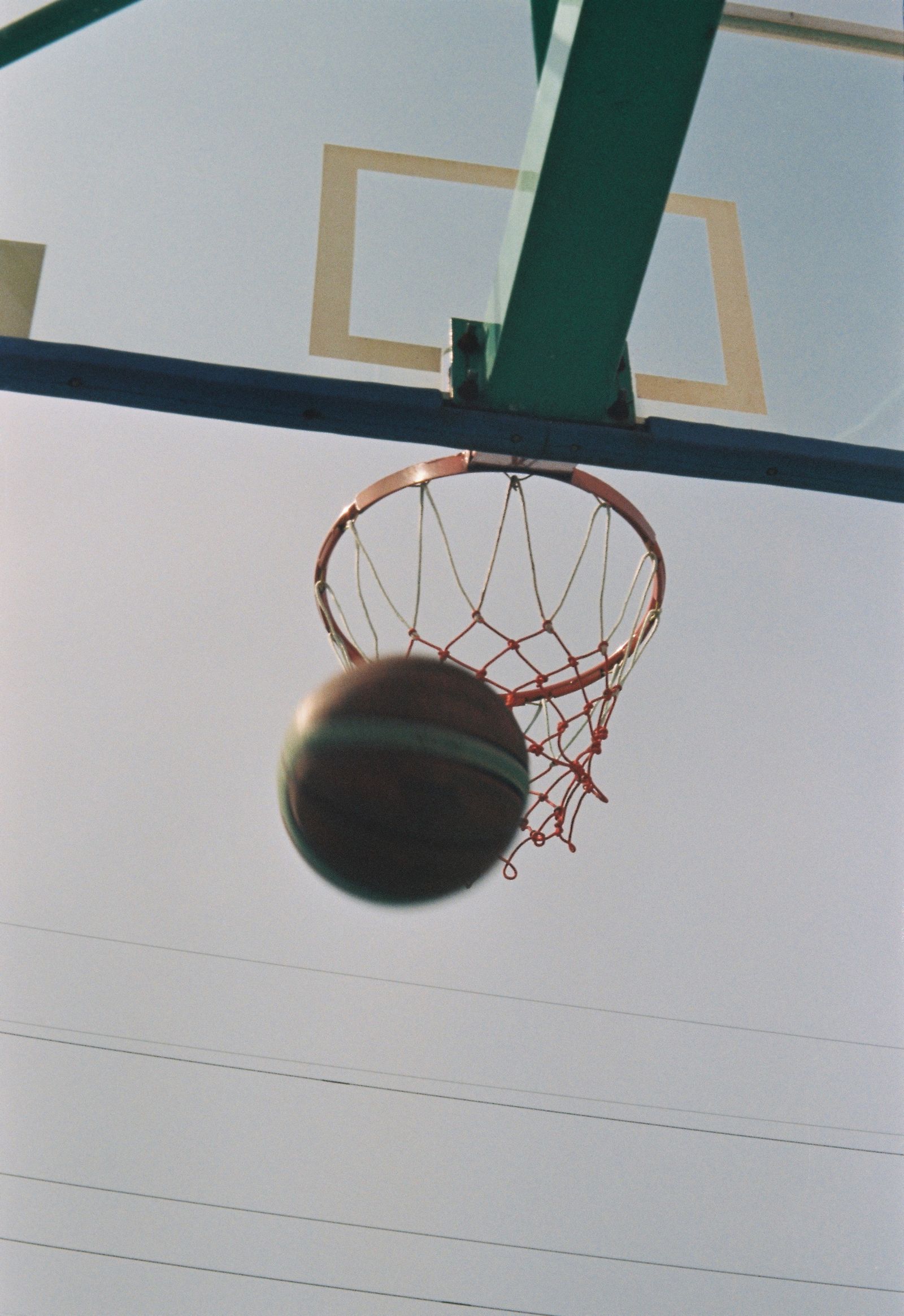 A basketball drops through the hoop and net