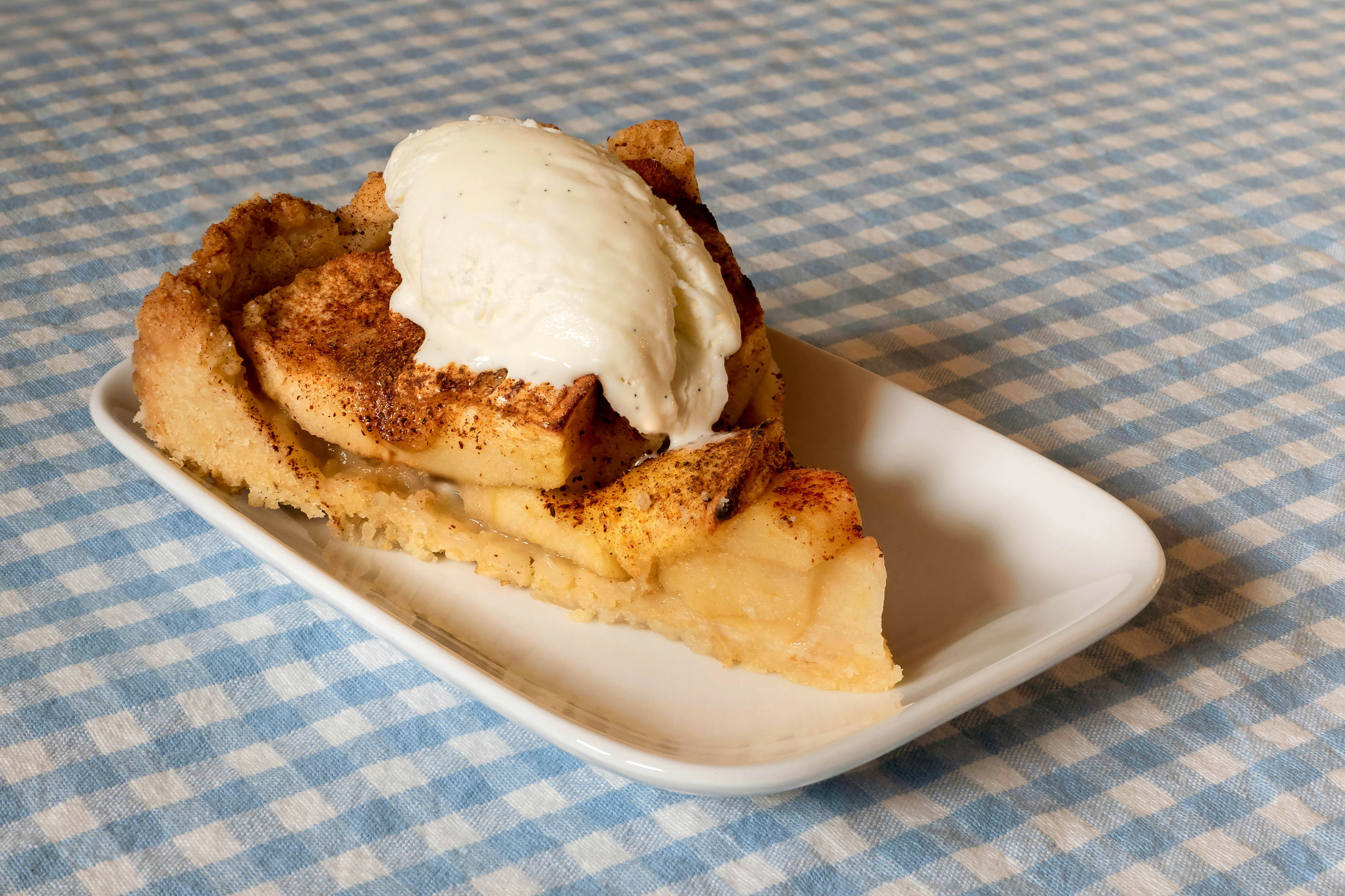 Apple cake with vanilla ice cream in a bowl