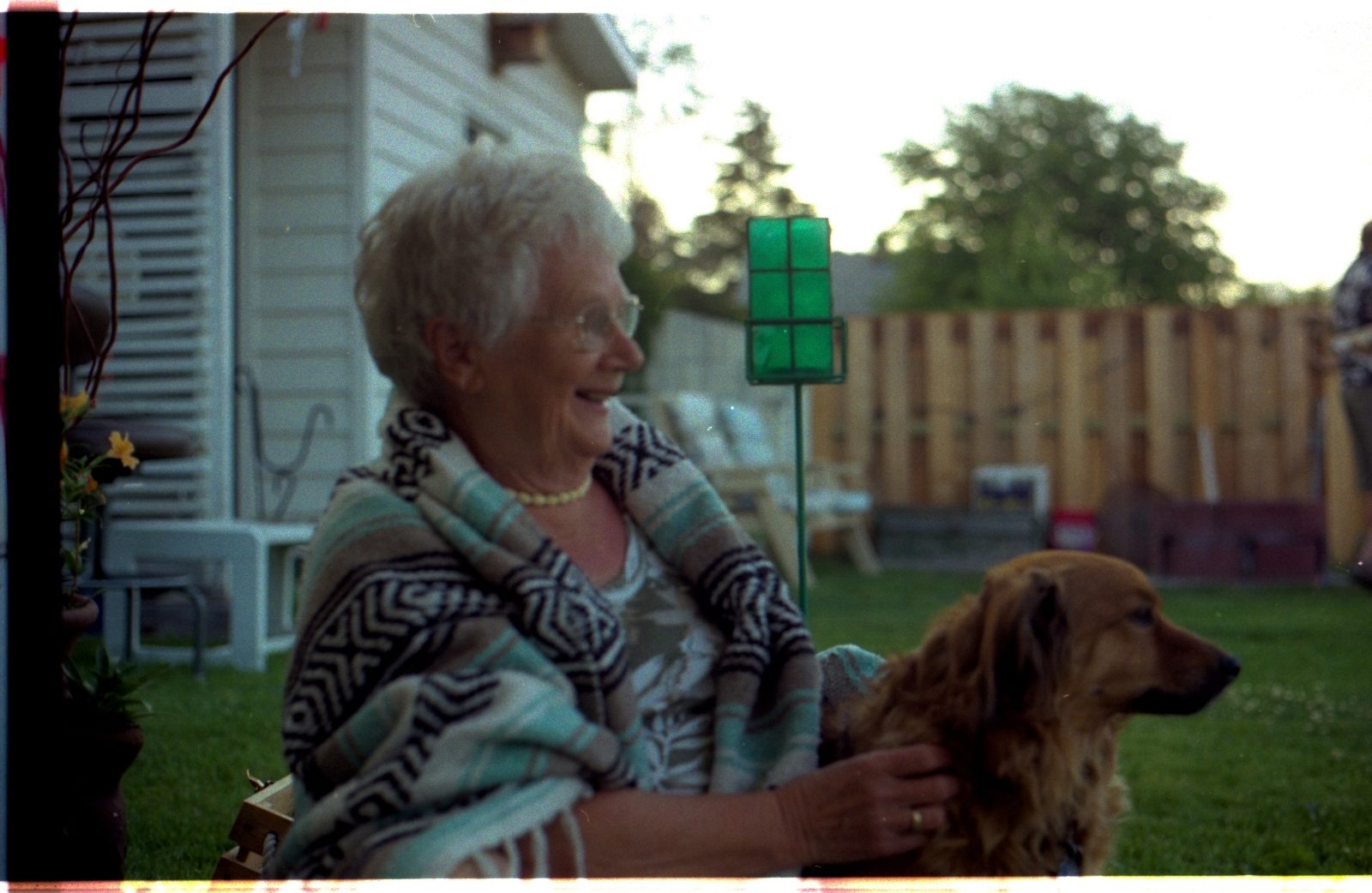 An older woman holds a golden retriever dog.