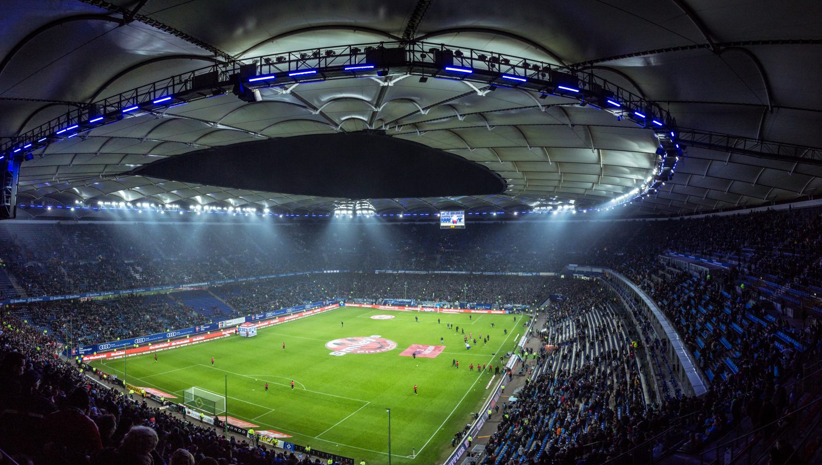 Soccer stadium lights glow over a night game