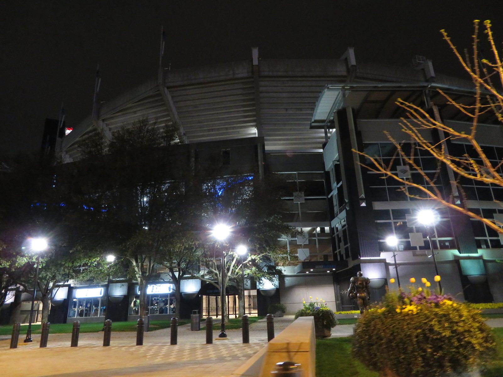 A packed football stadium with fans in the stands during a night game