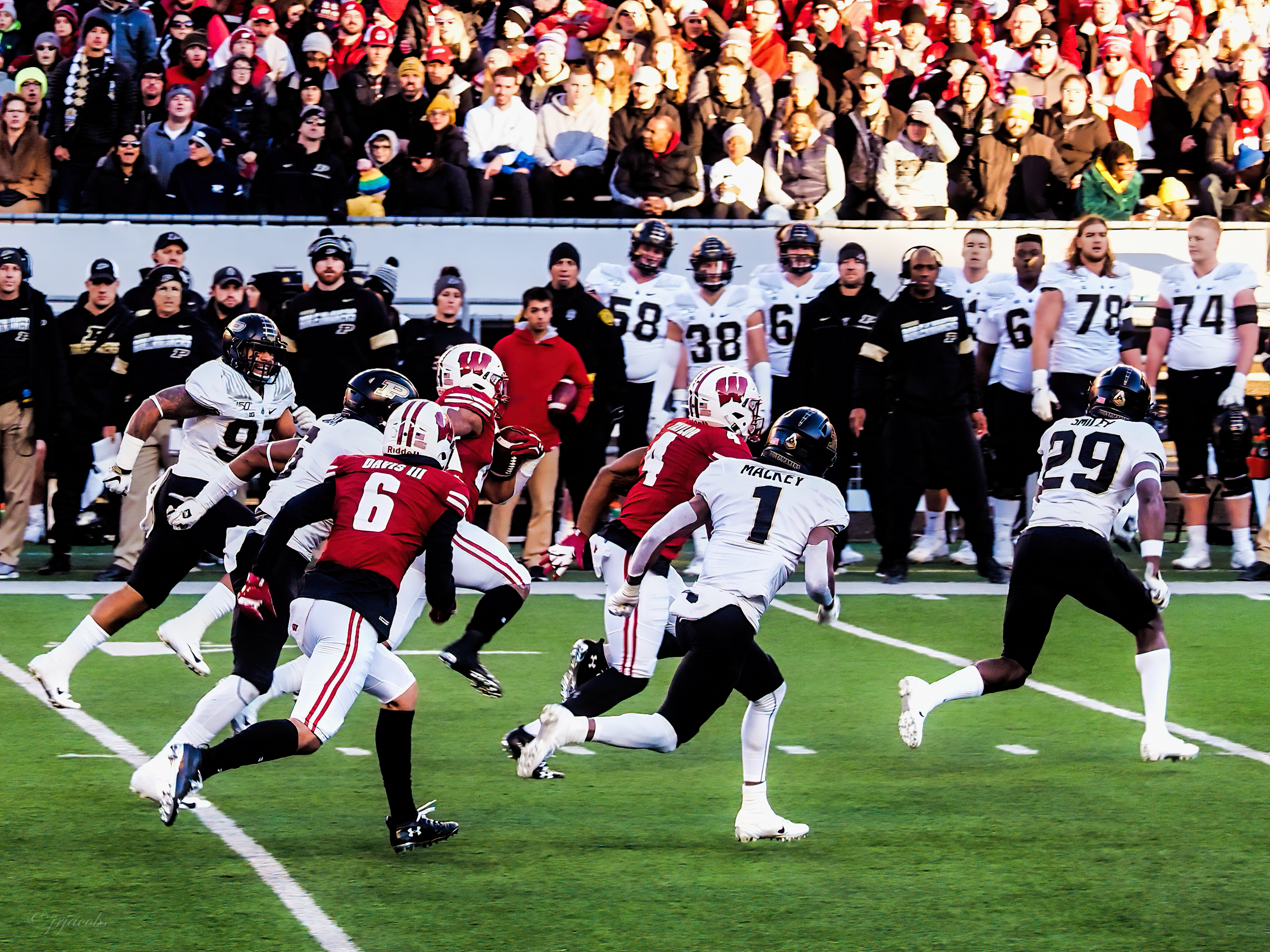 Football players run with the ball during a game