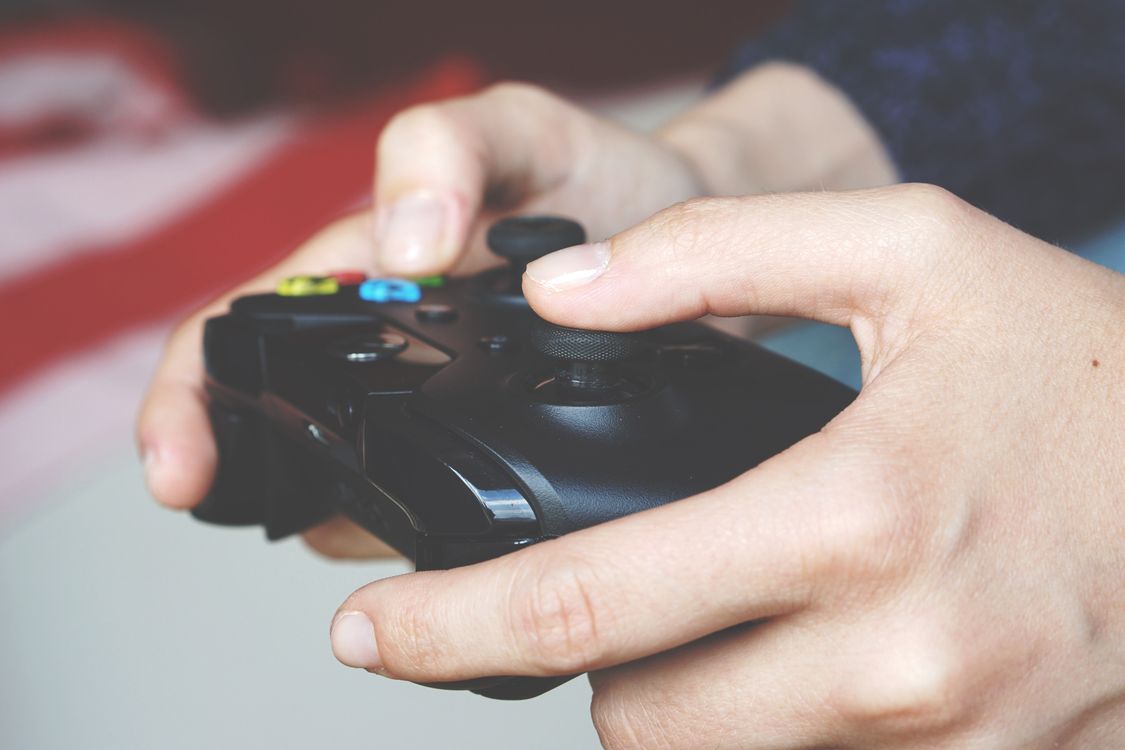 Hands hold a black game controller during a play session