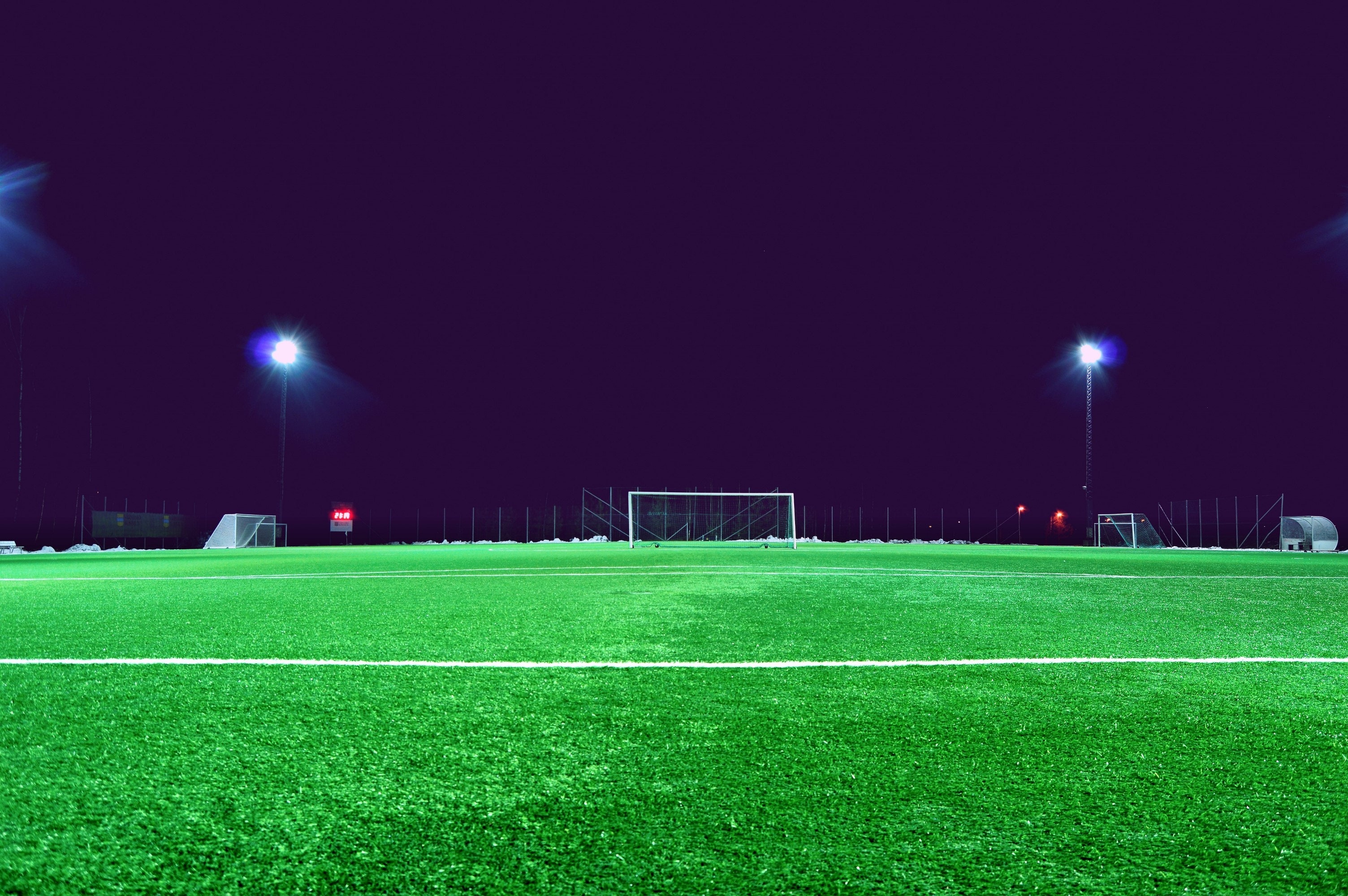 A soccer field under floodlights at night