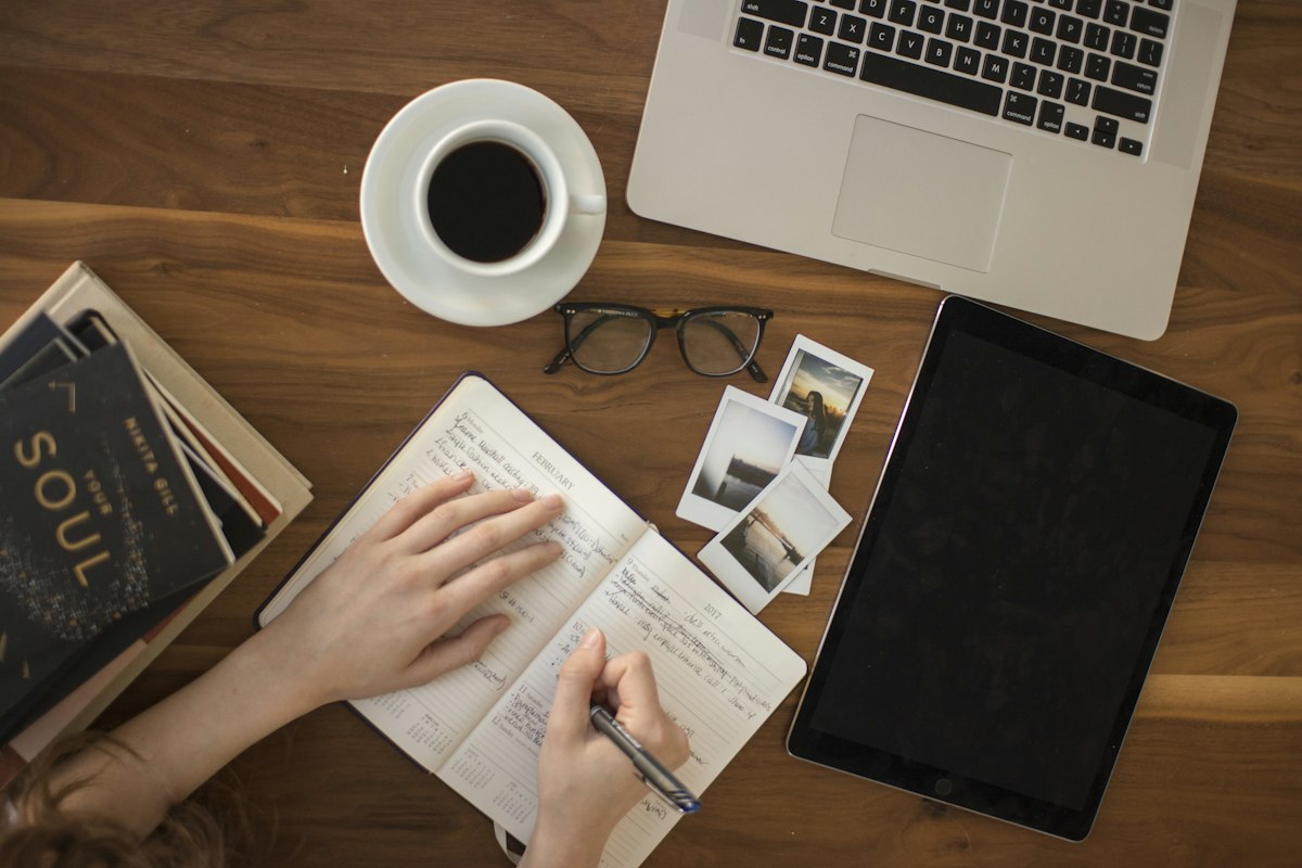 A person writing notes on paper at a desk