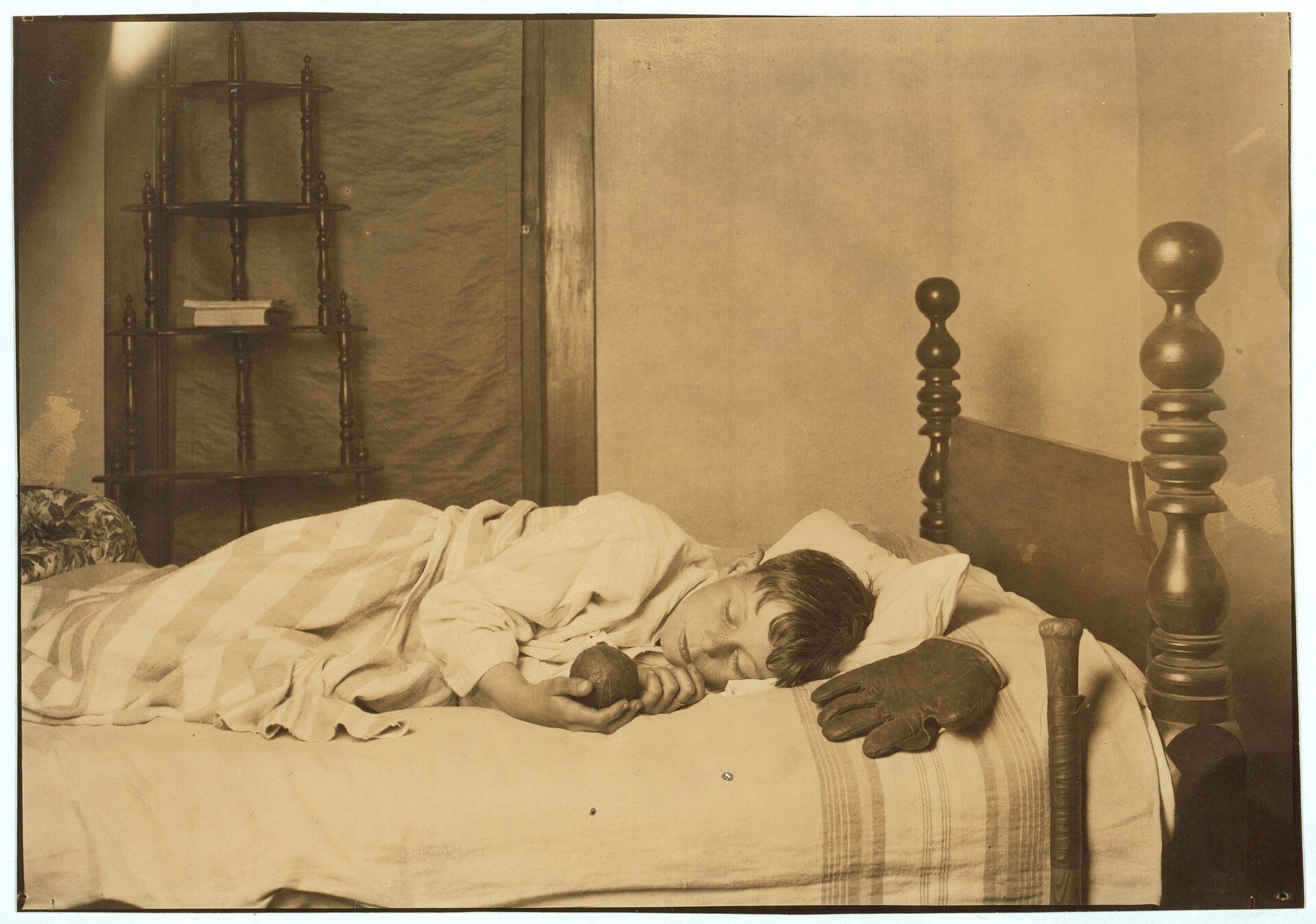 A boy asleep in bed, photographed by Lewis Hine