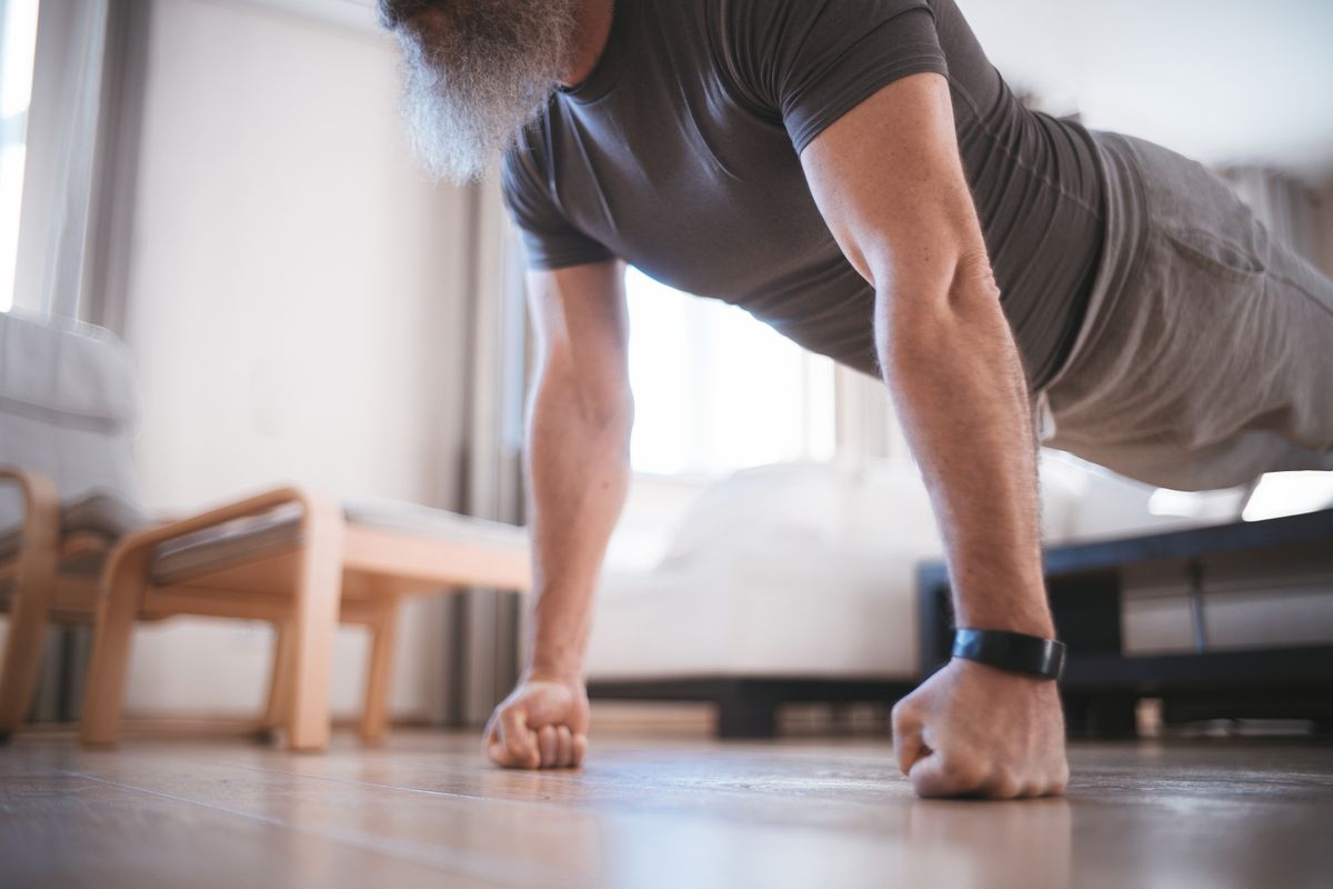 A man performing push-ups on the floor of his living room