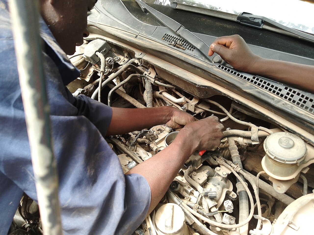 A mechanic working on a car engine