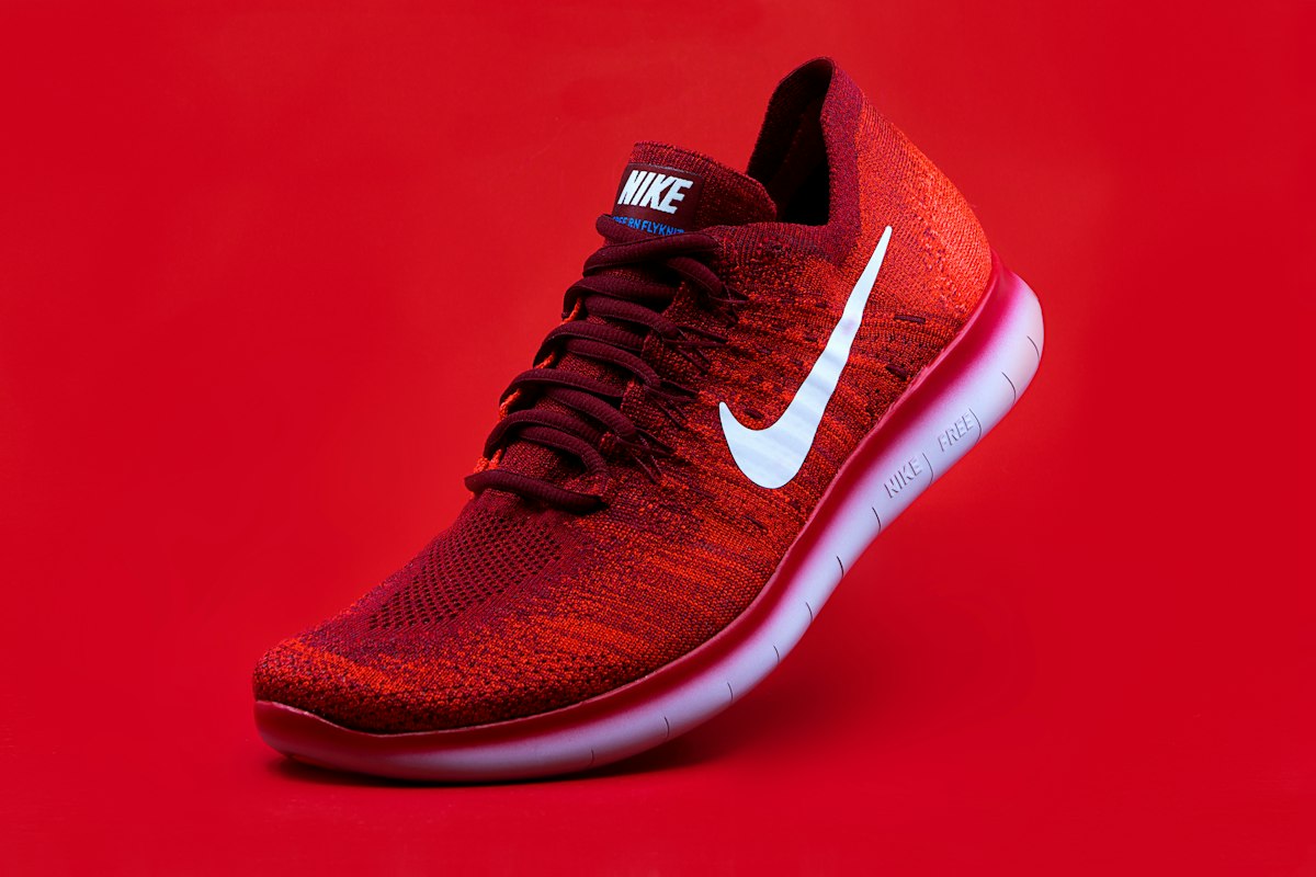 A pair of bright red running shoes on a plain background