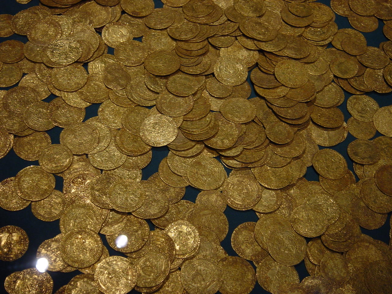 Gold coins spread out over a dark background