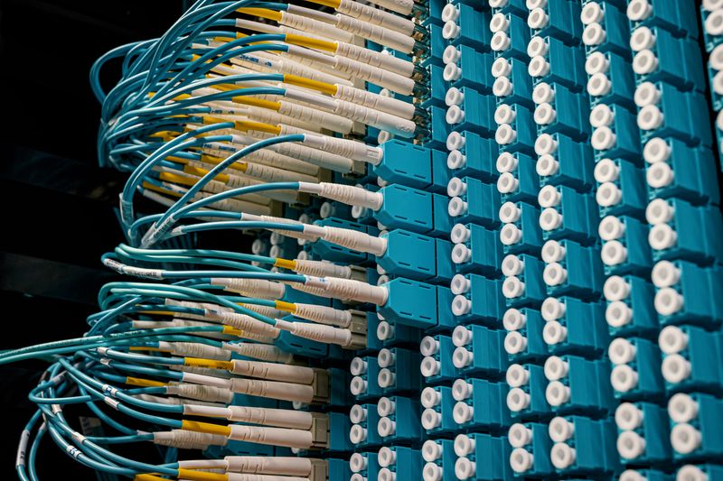 Fiber optic patch cables connected to a blue patch panel