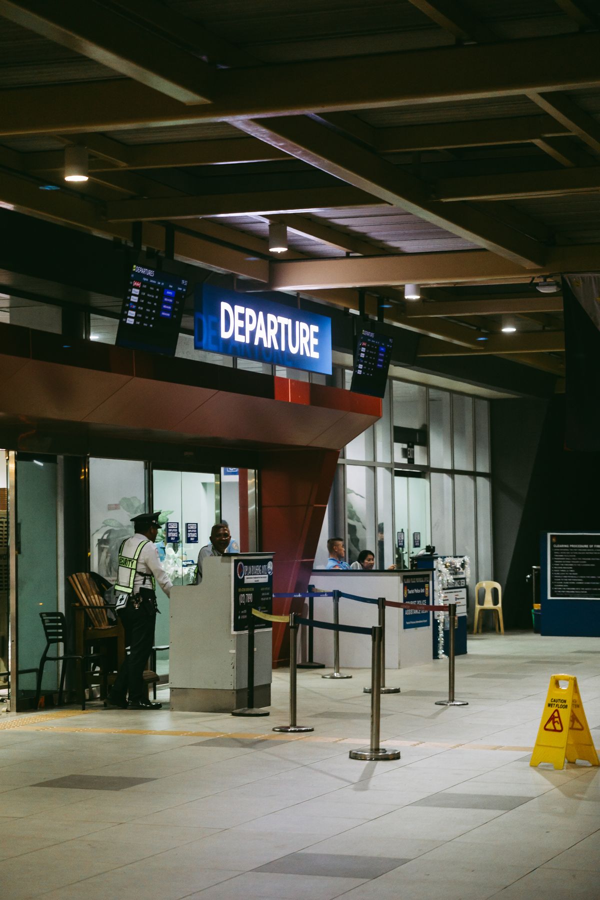 An airport departure gate at night, with staff and passengers in a modern terminal