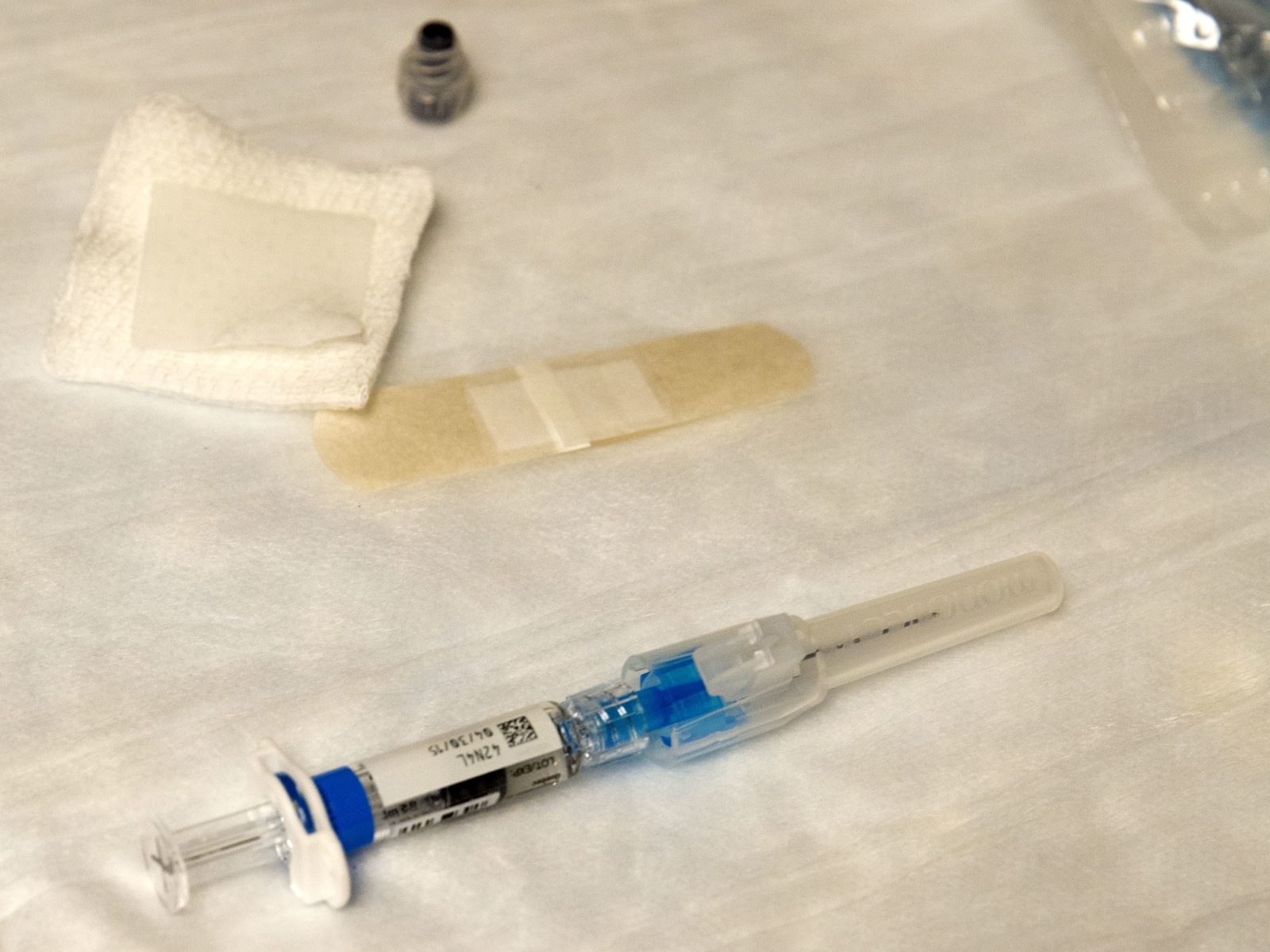 A flu vaccine waits on a table before injection