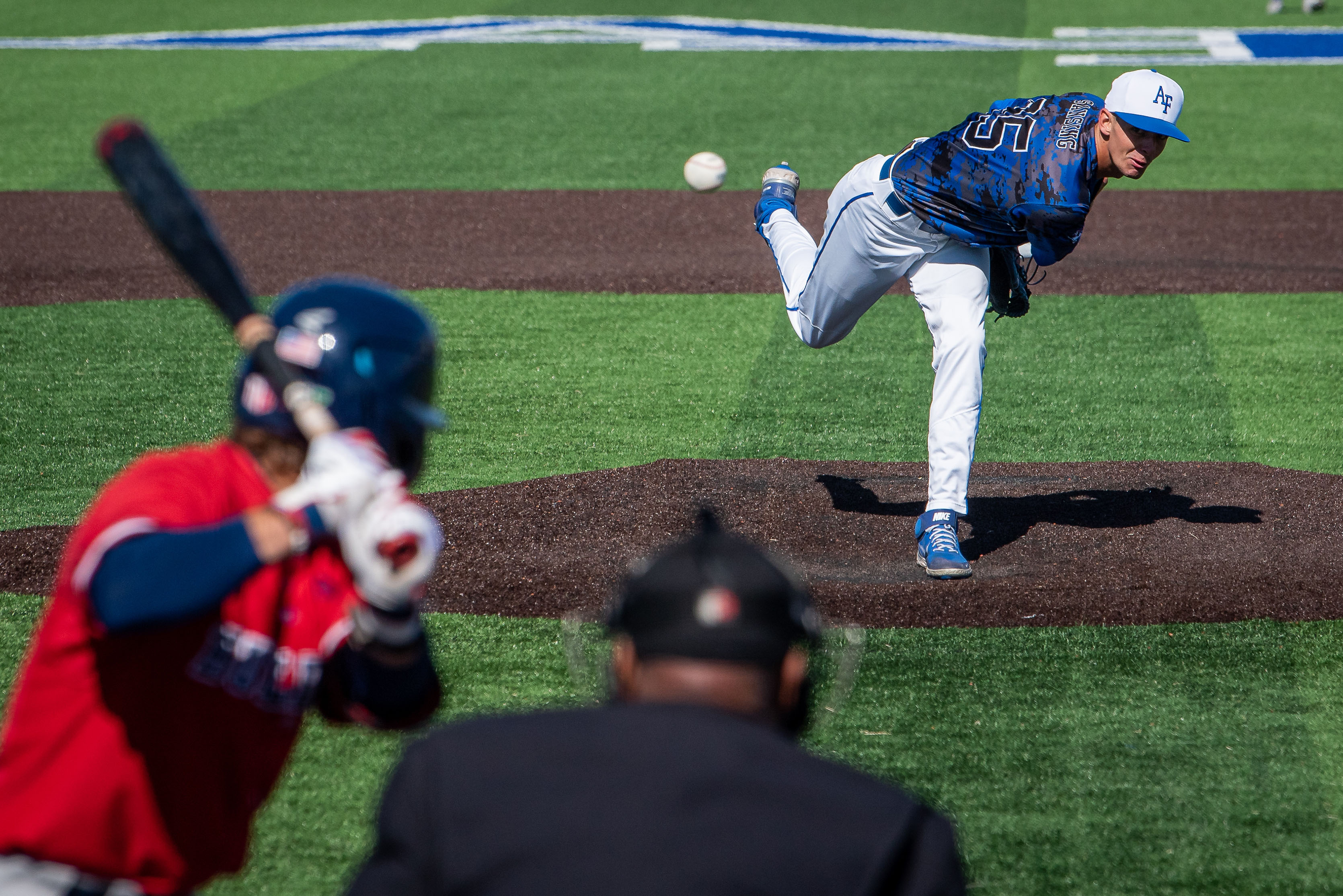 A pitcher delivers a pitch toward a batter during a baseball game