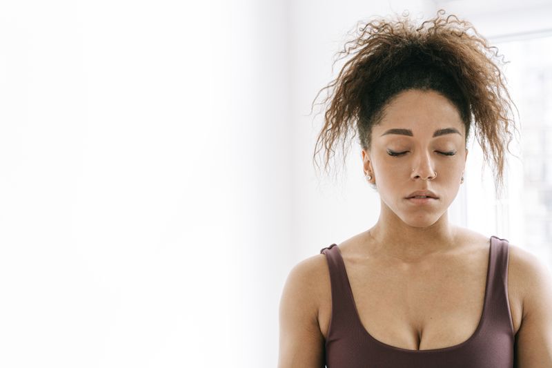A woman meditating with her eyes closed