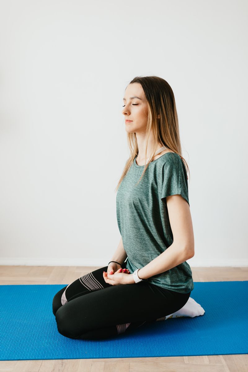 A woman meditating on a yoga mat outdoors