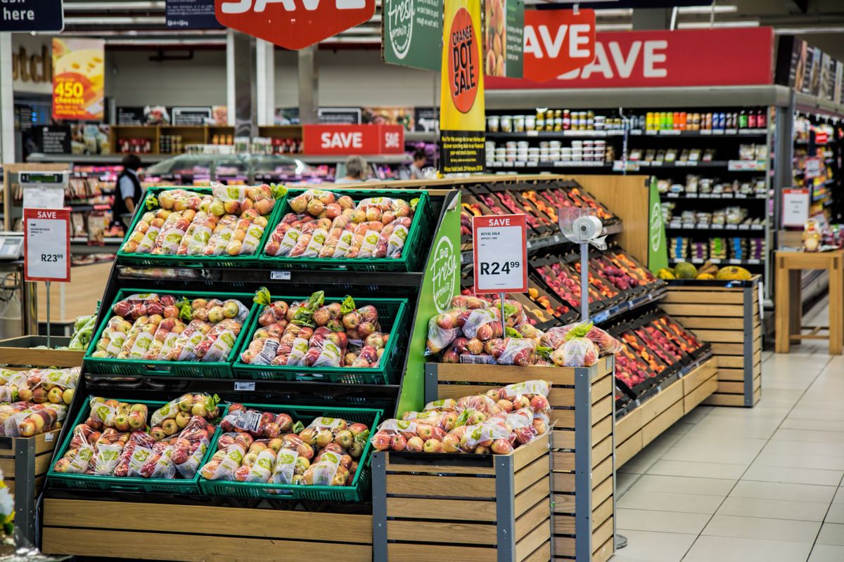 A produce aisle in a supermarket with discount signage