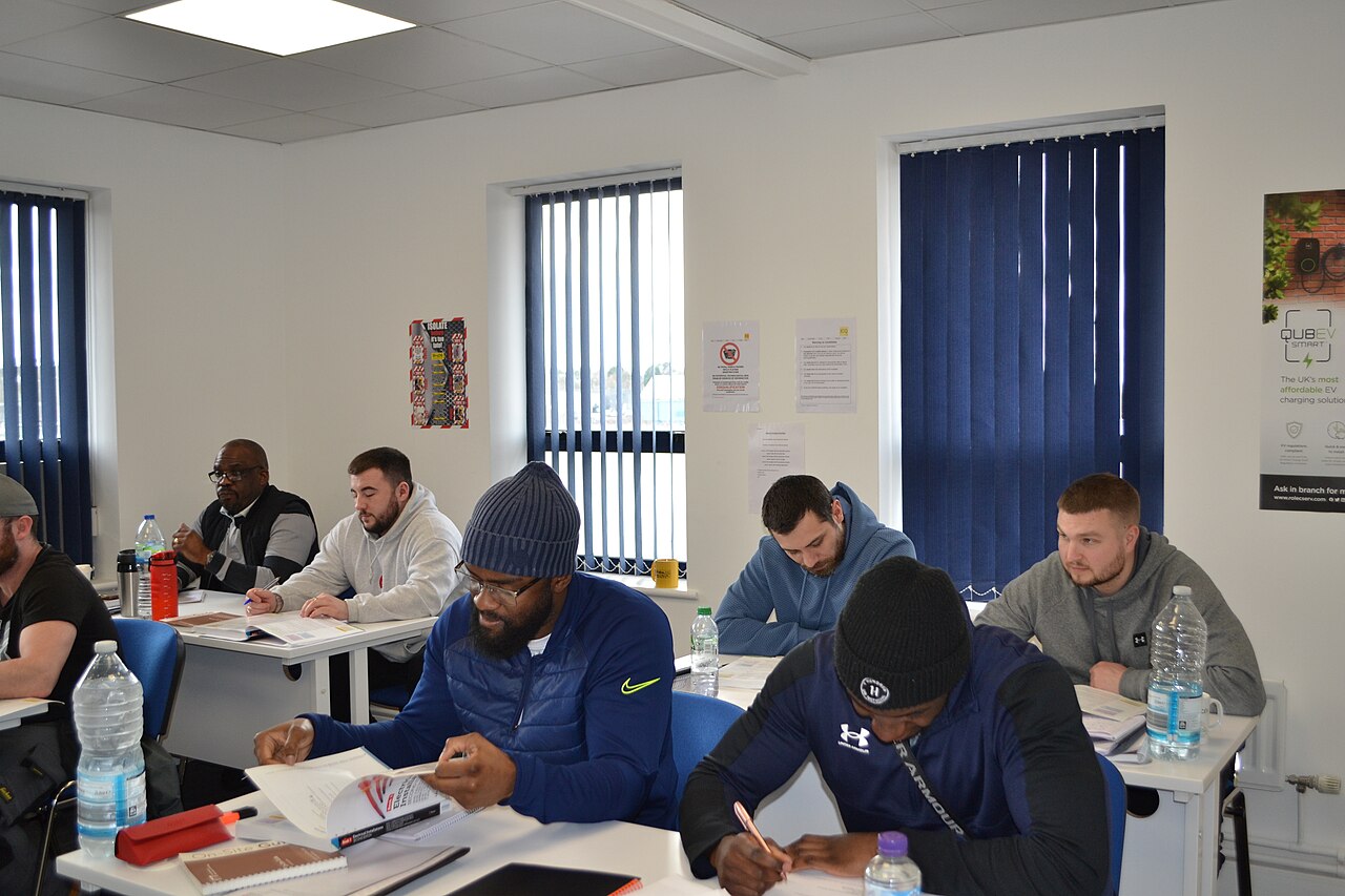 Adult learners studying at desks in a classroom