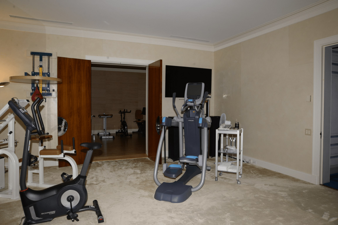 EFTA00000258 - Well-equipped home gym featuring exercise bikes an elliptical machine and a television screen