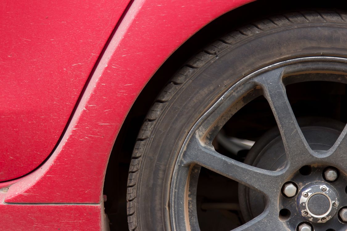 A close-up of a car wheel and tyre showing tread and wear