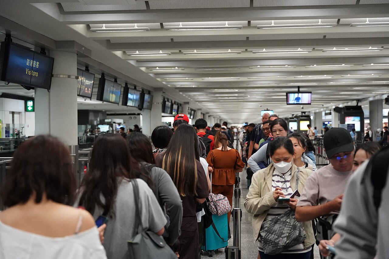 Travelers queue at immigration in Hong Kong International Airport