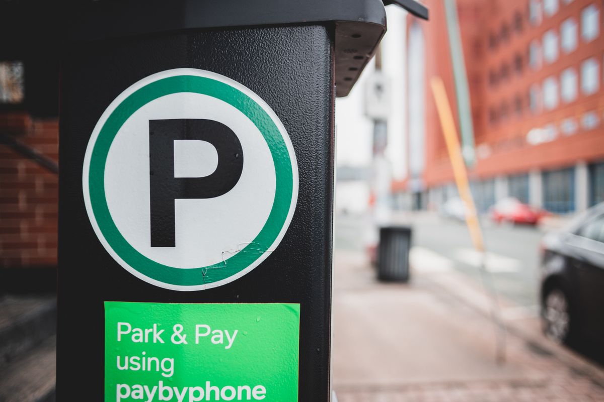 A parking meter with a Park and Pay sign on a city street