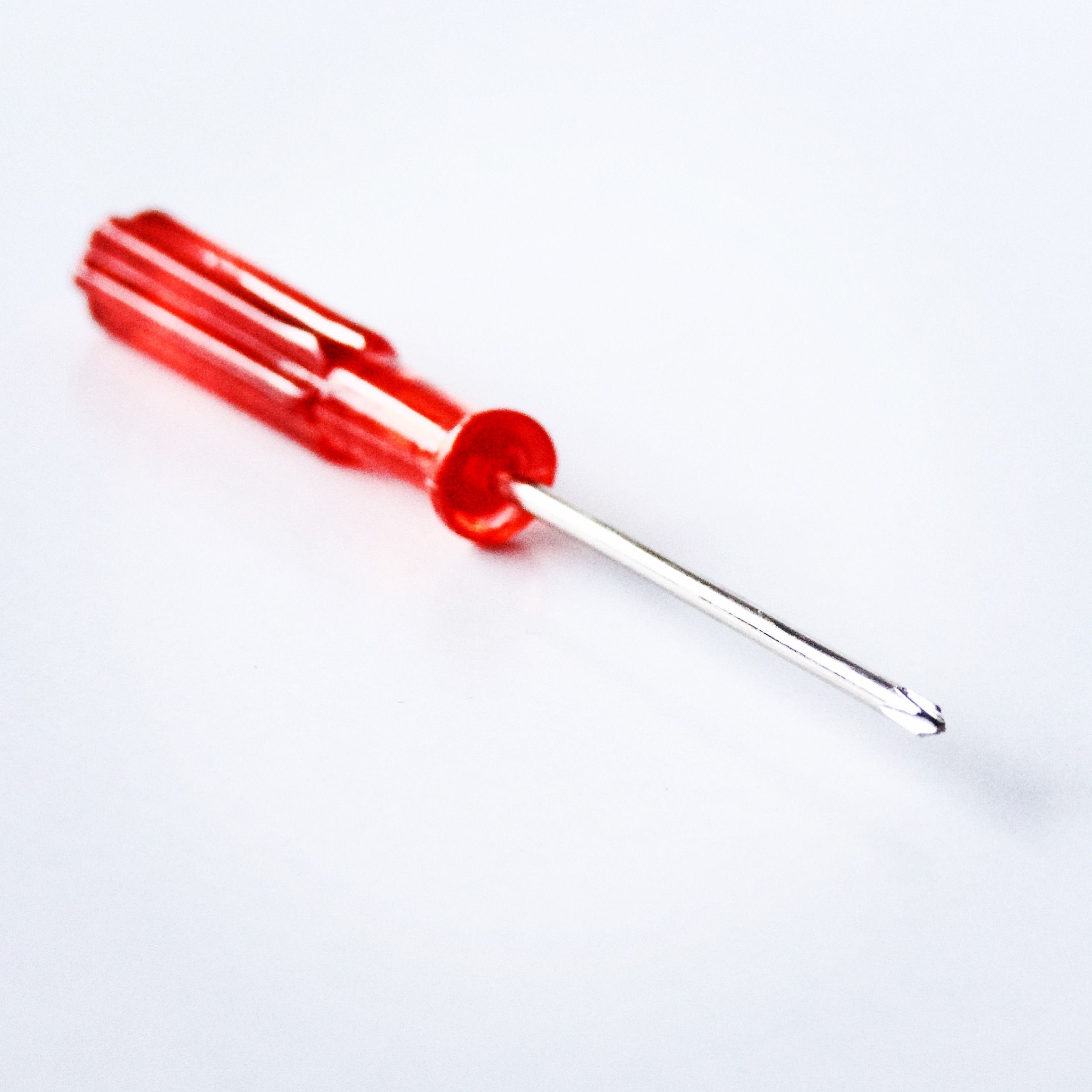 A close-up of a red screwdriver, showing the tip that must seat firmly in the screw head