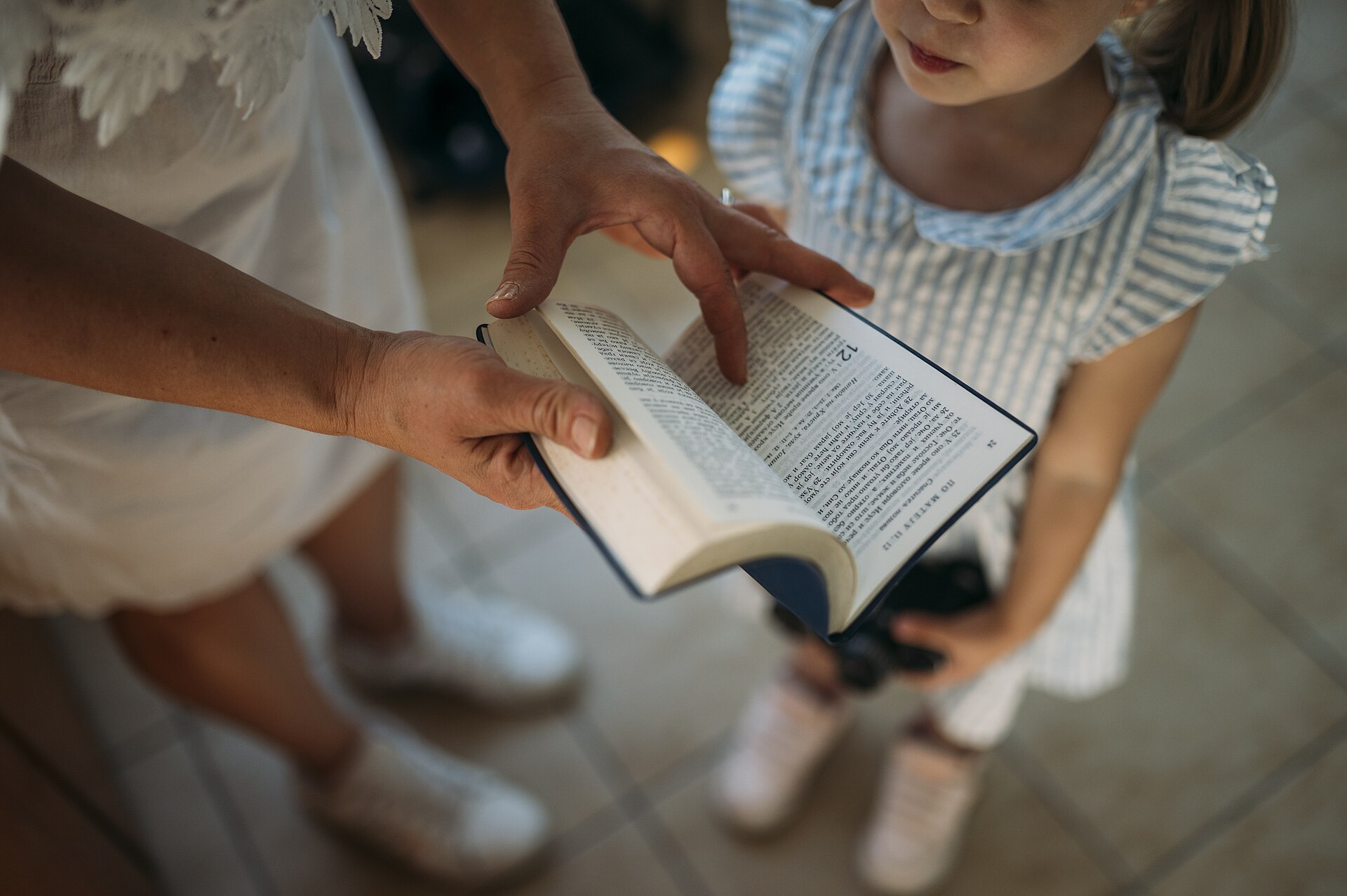 A child listening as an adult reads from a book