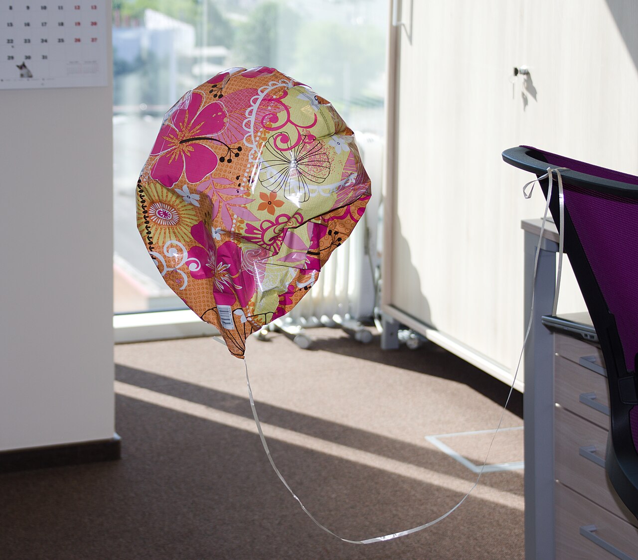 A half-deflated toy balloon resting on a surface