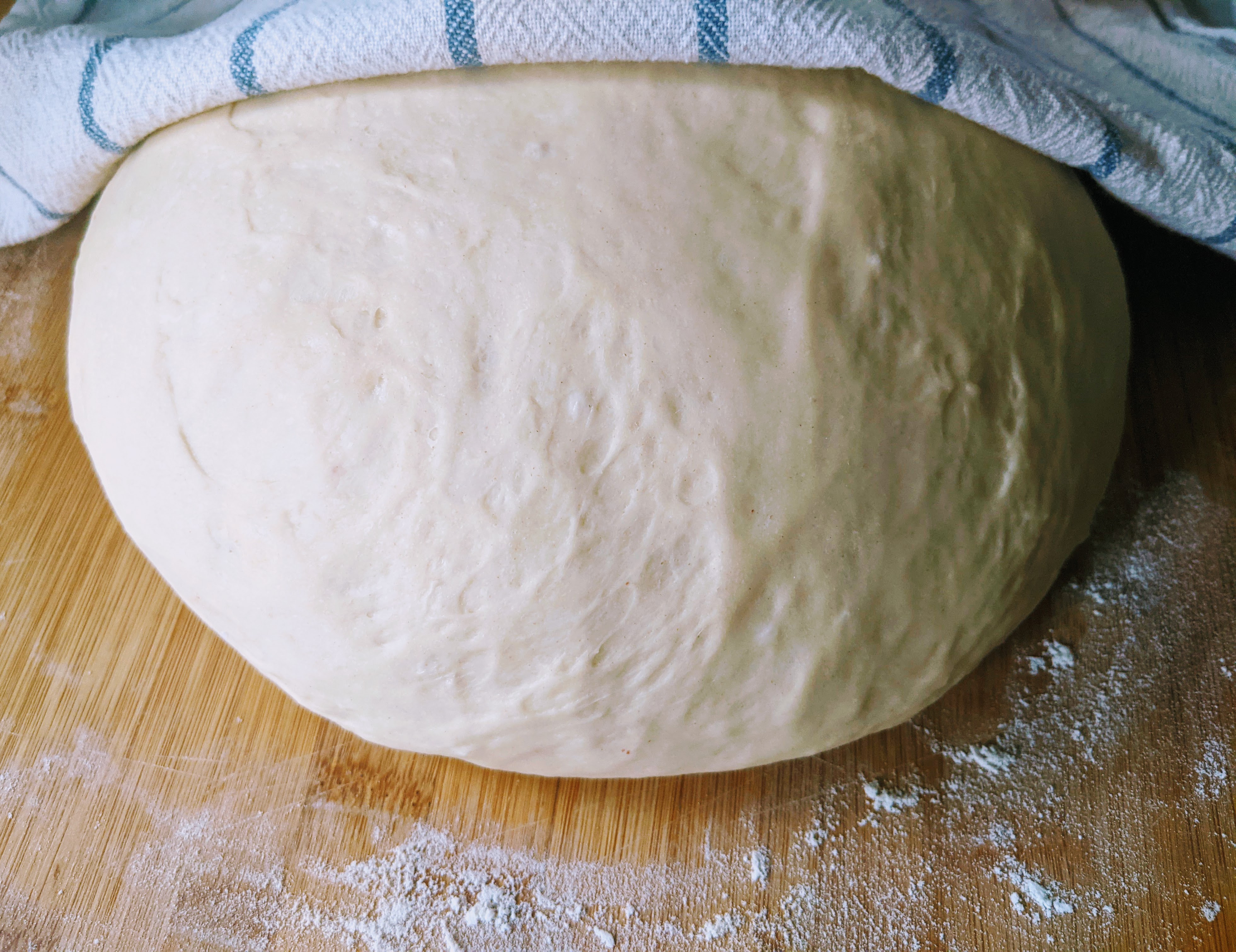 Risen bread dough full of gas bubbles in a bowl