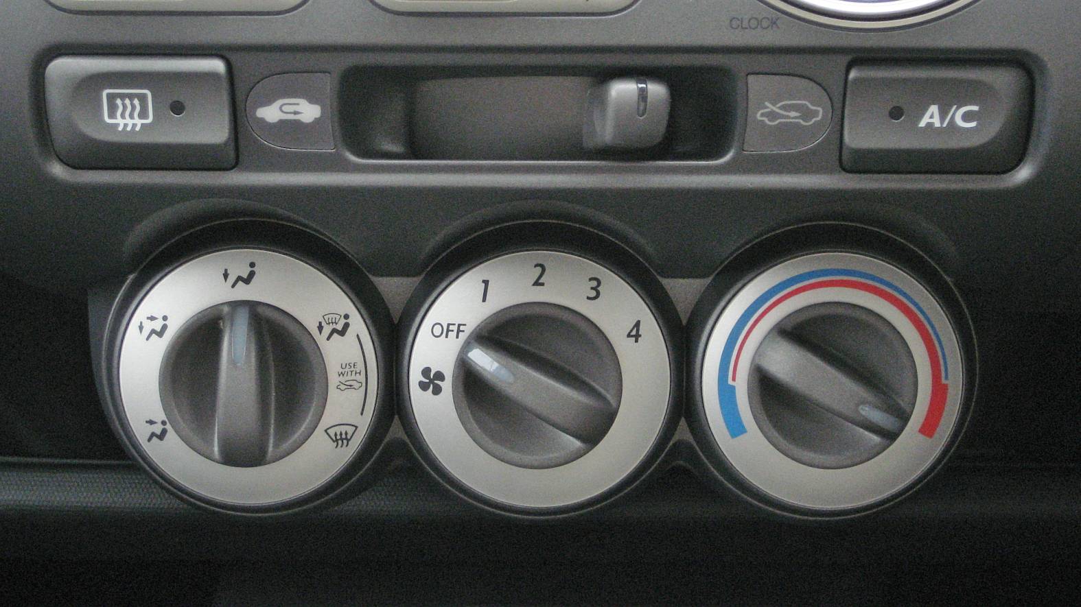Manual air conditioning controls on a first-generation Honda Fit dashboard