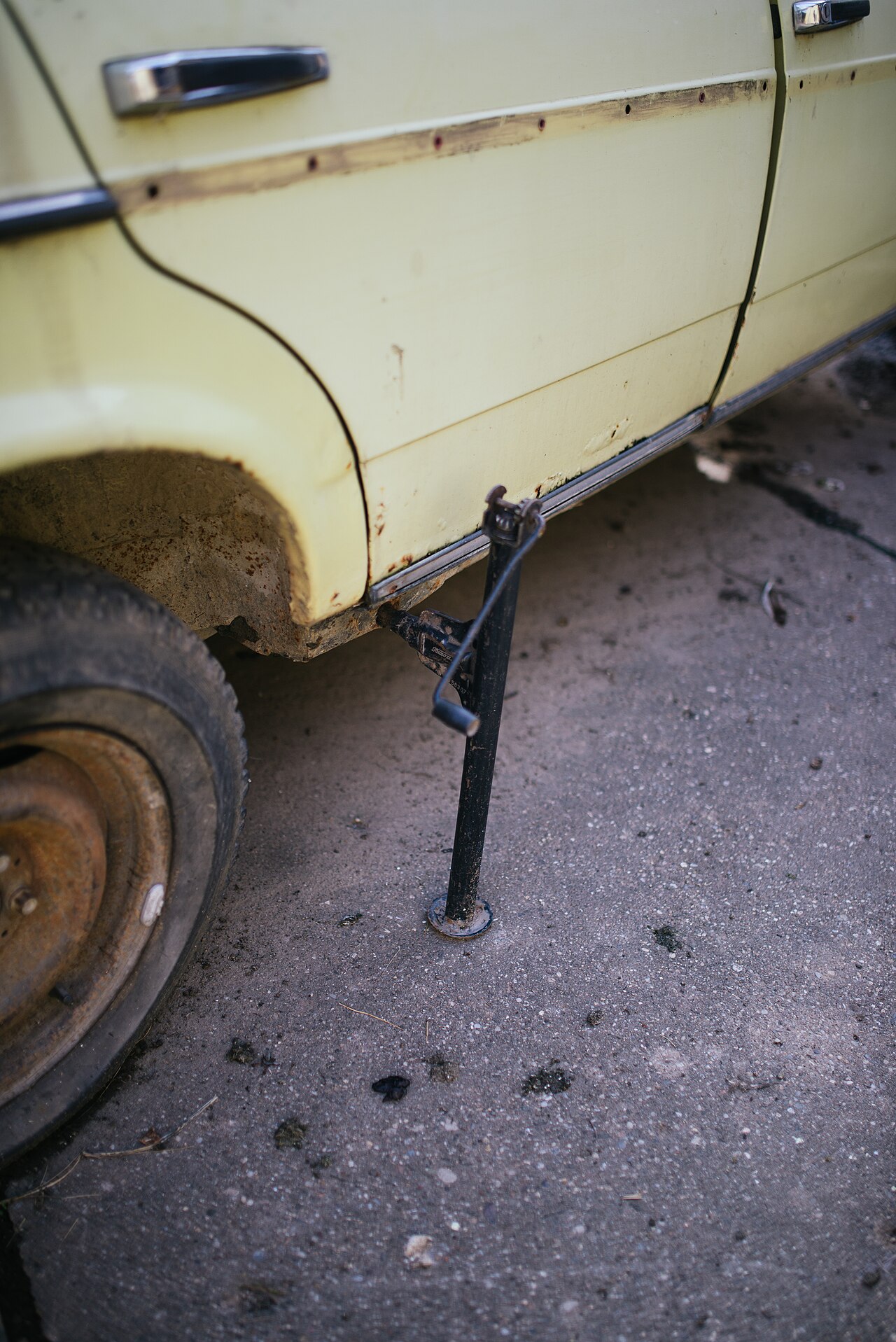 A scissor jack lifting the side of a car