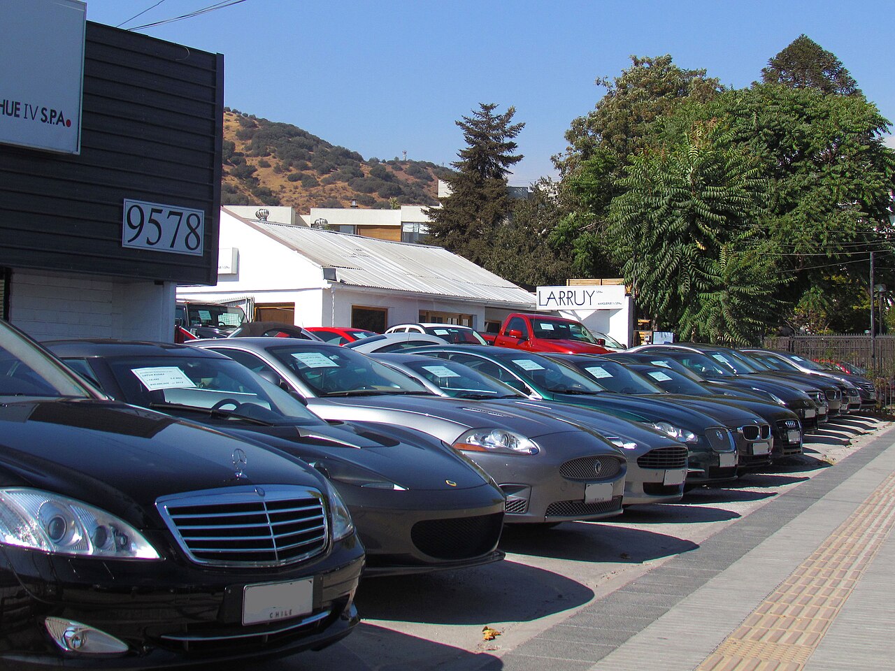 A row of used cars parked at a dealership lot