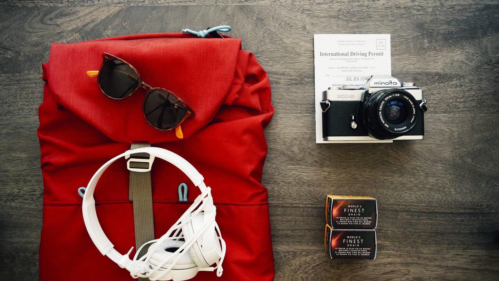 A packed backpack with clothes and travel gear laid out beside it