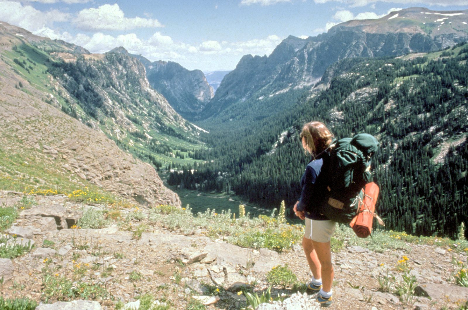 A hiker with a backpack on a mountain trail