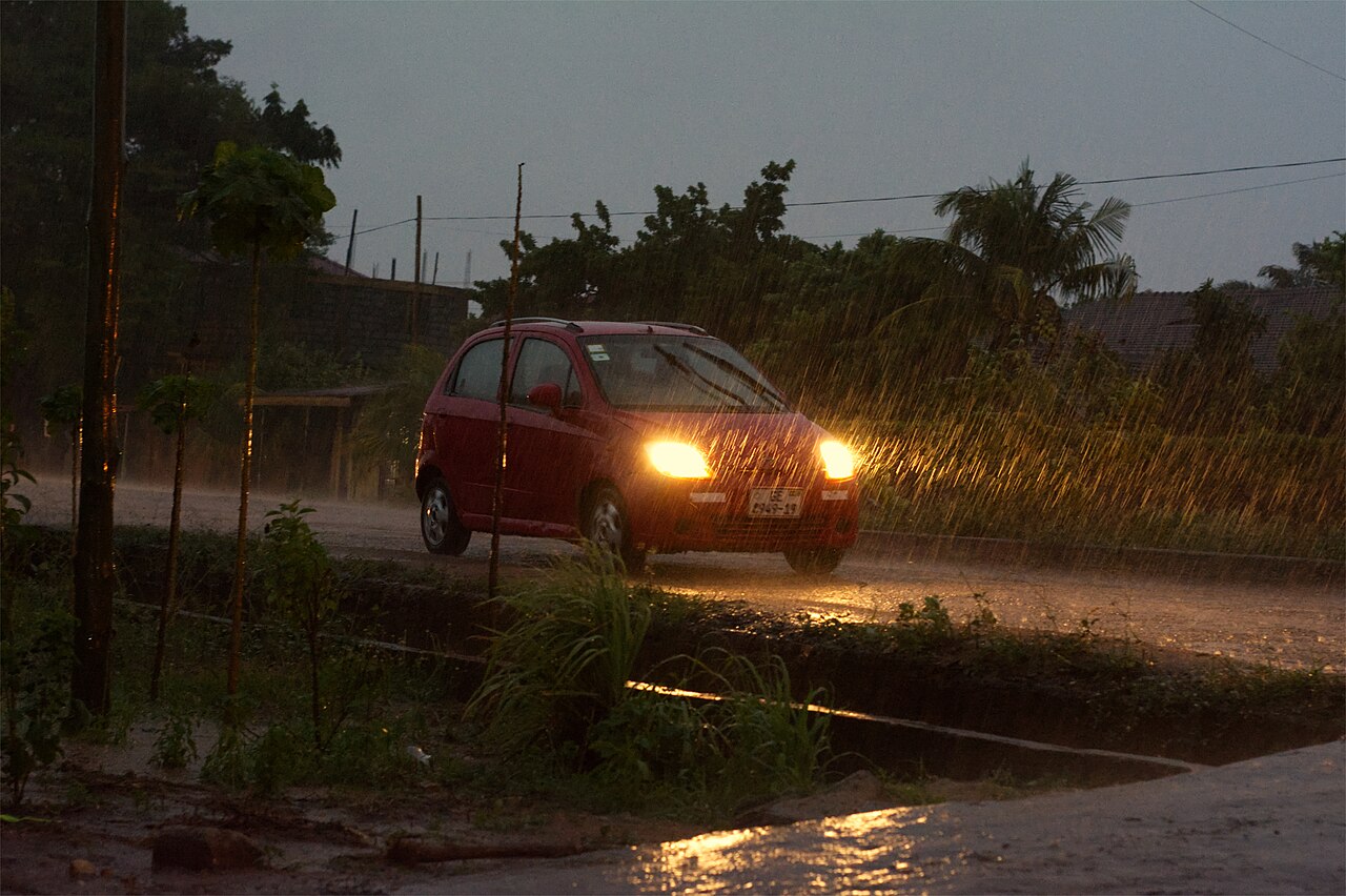 Headlight beams shining through rain at night