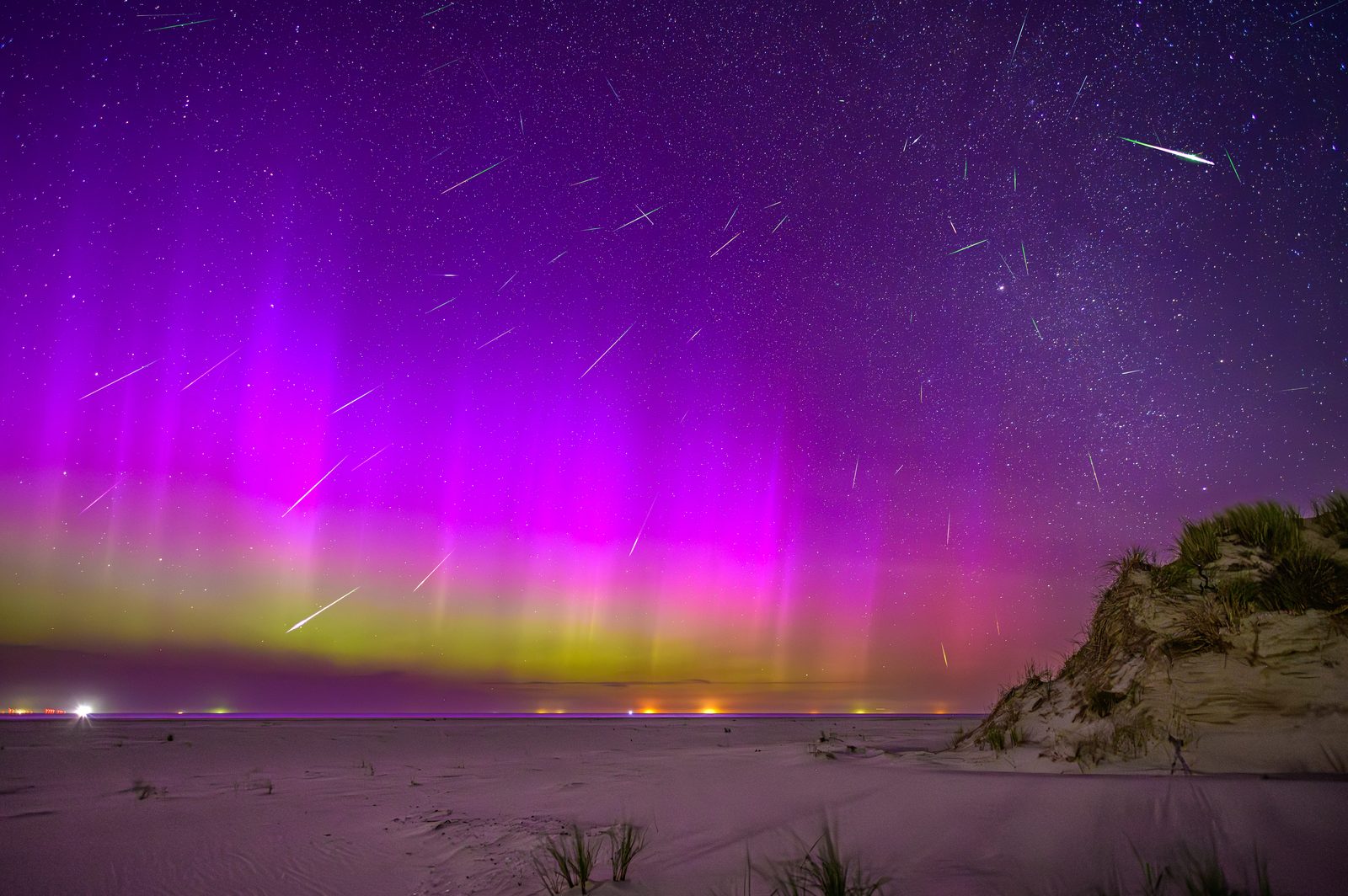 Aurora in the sky with Perseid meteors above the horizon
