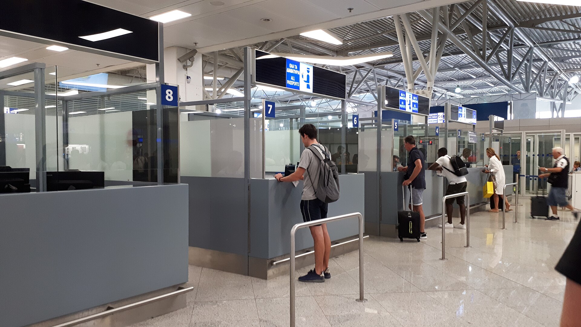 Travellers at passport control booths in an airport